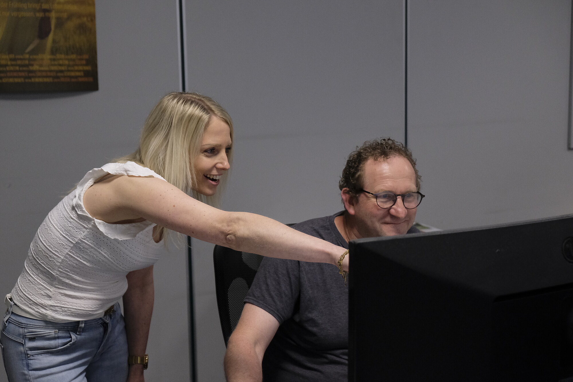 zwei Menschen schauen in der Vorstufe auf einen PC