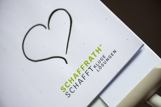 Detailansicht eines Flipcharts, auf dem ein gemaltes Herz und das Schaffrath-Logo zu sehen ist