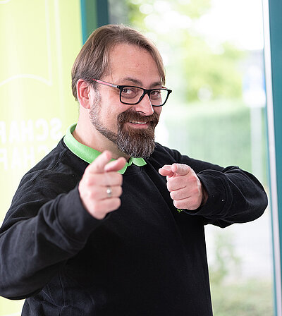 Mann, der mit den Fingern an den Betrachter zeigt