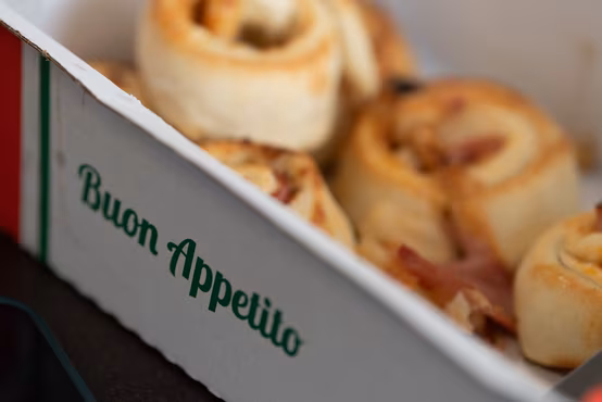 Nahaufnahme von gefüllten Pizzabrötchen im Karton