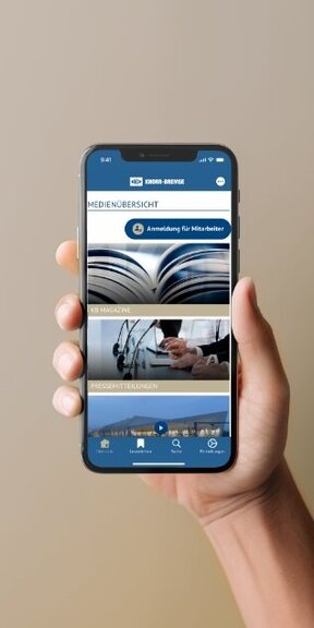 Vor einem farbigen Hintergrund hält eine Hand ein iPhone auf dem die App von Knorr Bremse dargestellt wird