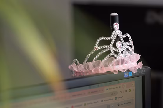 Silber-Rosagarbene Krone, die auf einem Monitor steht
